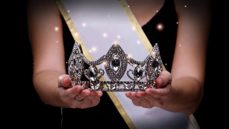 femeie care ține în mână o coroană pentru concursul de Miss