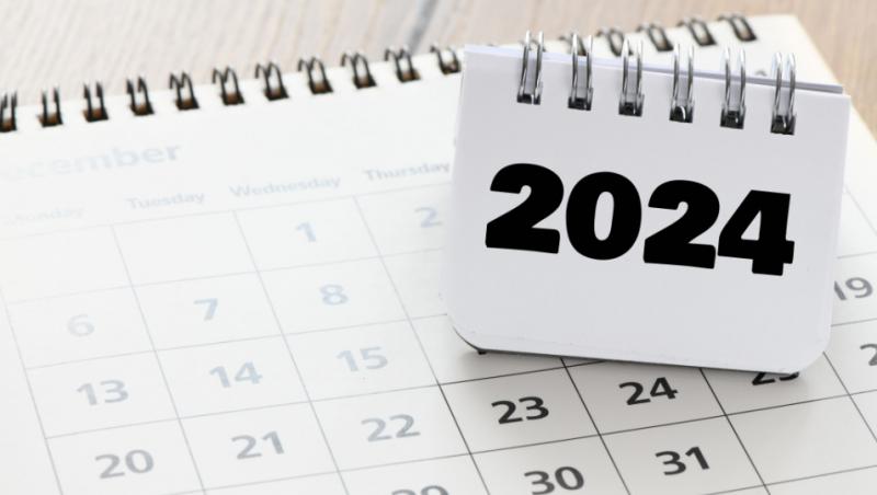 Imagine cu un calendar care indică anul 2024 stând pe un calendar al unei luni.