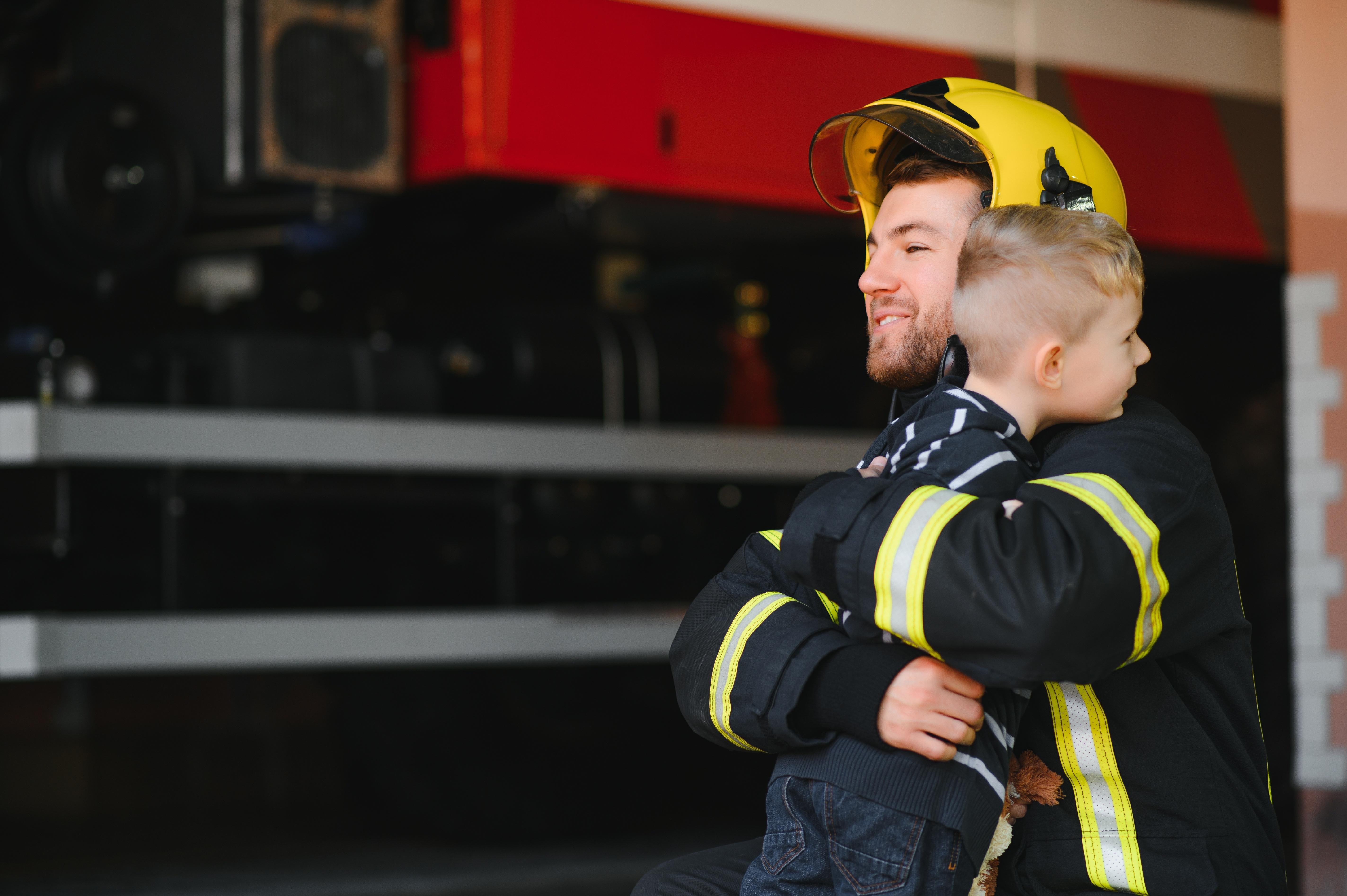 imagine cu un baietel care imbratiseaza un pompier