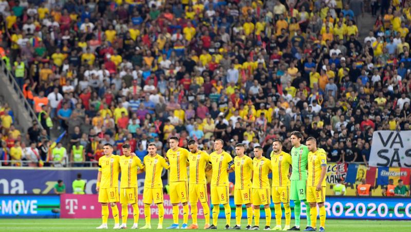 jucatorii nationalei de fotbal romania imbracati in galben stau in mijlocul terenului