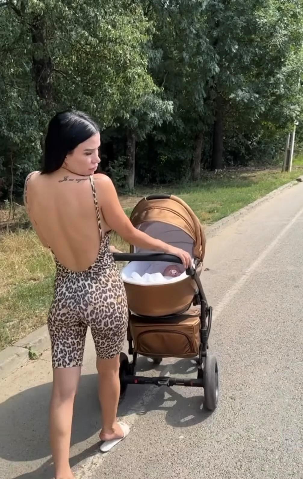 Daniela Crudu în salopetă animal print cu copilul în cărucior