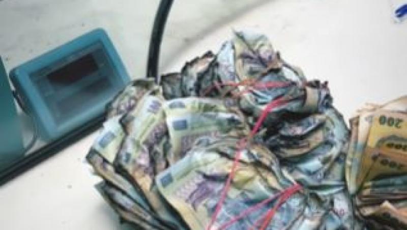 Un bărbat a dus mai multe teancuri de bancnote arse în fața BNR. Reacția instituției când a văzut asta