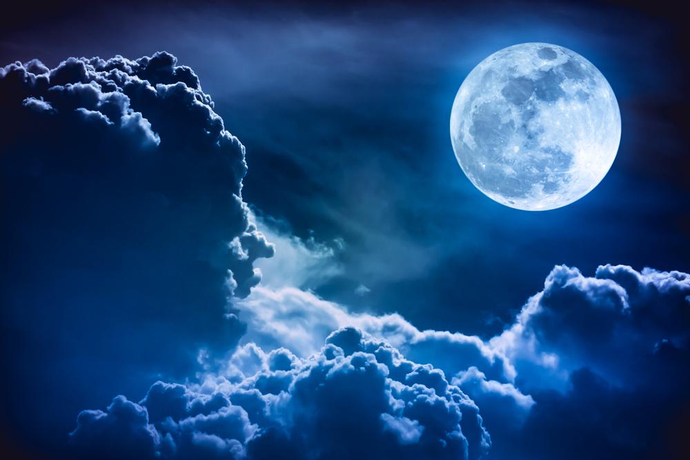 luna plina si albastra care emana lumina pe un nor
