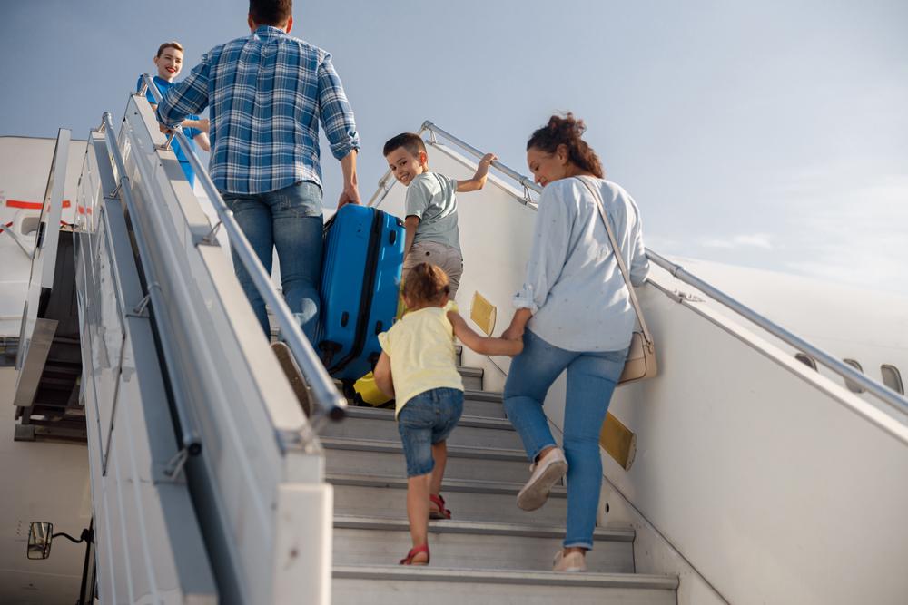 familie compusa din barbat si femeie si doi copii urca în avion