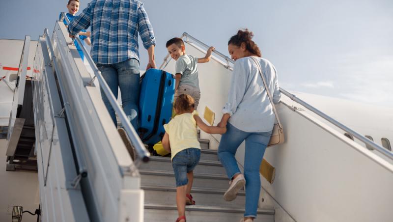 familie compusa din barbat si femeie si doi copii urca în avion