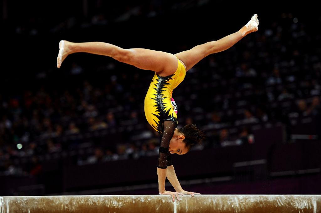 Larisa Iordache executând un exercițiu la bârnă
