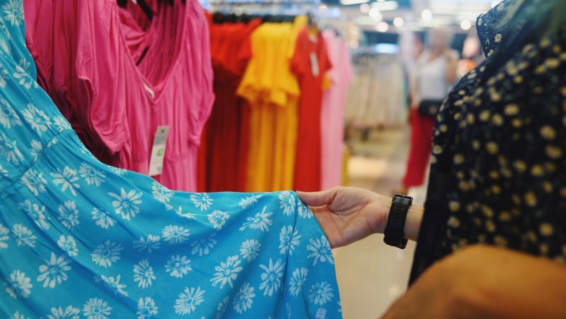 imagine cu o femeie care se uita la haine din magazin