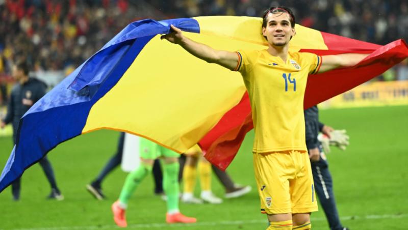 Imagine cu Ianis Hagi ținând în mână steagul României pe terenul de fotbal.