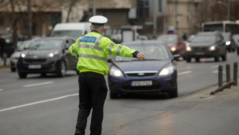 Imagine cu un polițist care oprește un conducător auto pentru un control de rutină.