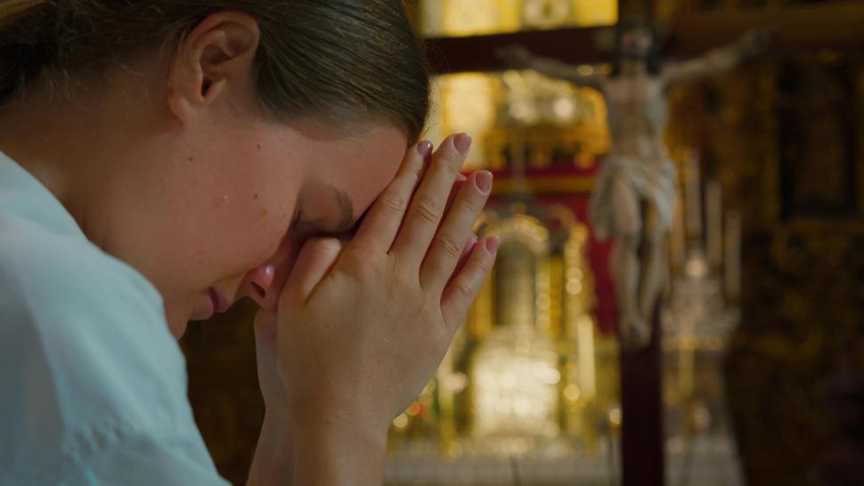 Imagine cu o femeie care rostește o rugăciune.
