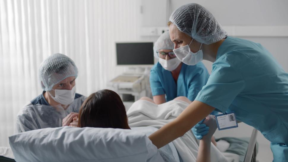 Imagine cu o femeie în sala de operație pentru naștere