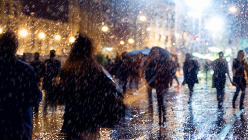 imagine cu oameni pe strada intr-o zi ploioasa