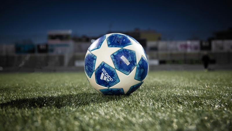 O minge albă cu petrice albastre pe terenul de fotbal