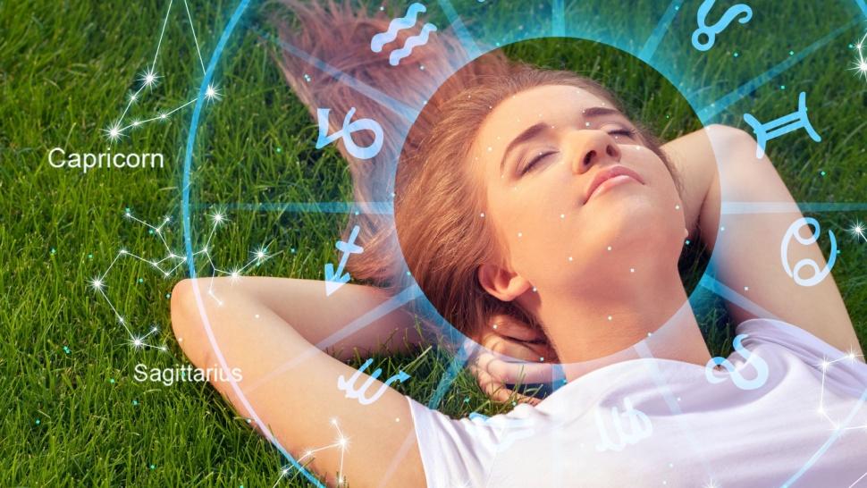 Tânără care se relaxează la soare pe iarbă și semnul zodiacului