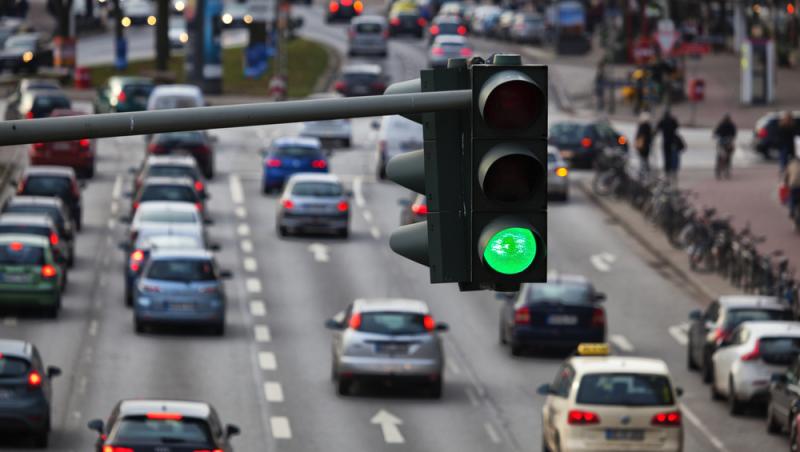 mașini în trafic pe multiple benzi și semafor pe culoarea verde