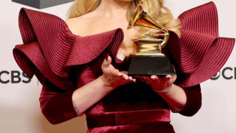 adele ținând în mână un trofeu pe covorul roșu