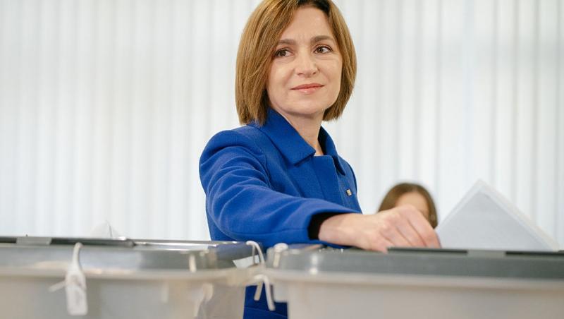 Maia Sandu îmbrăcată cu un costum albastru, participând la alegeri