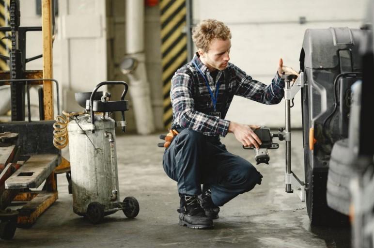 Un mecanic cu un compresor de aer