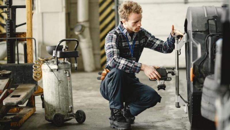 Un mecanic cu un compresor de aer