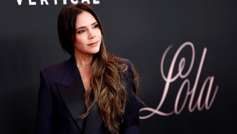 Victoria Beckham îmbrăcată într-un costum negru elegant
