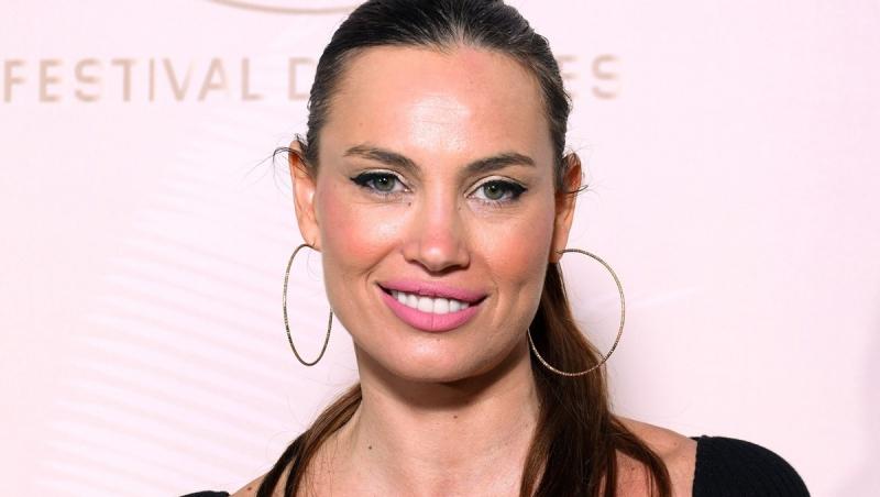 Alina Pușcău îmbrăcată într-o ținută neagră, accesorizată cu cercei rotunzi mari