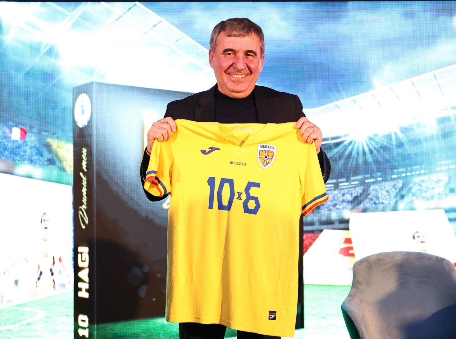 Gheorghe Hagi îmbrăcat în negru, ținând în mâini un tricou al naționalei de fotbal a României