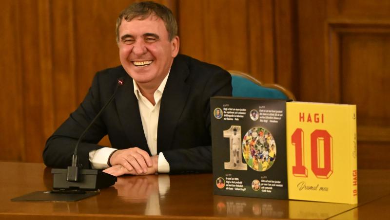 Gheorghe Hagi îmbrăcat cu un costum negru, la o conferință de presă