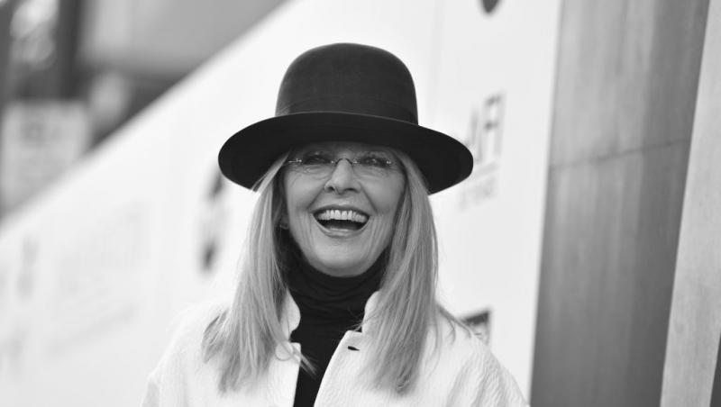 Diane Keaton în haine albe și negre cu zâmbetul pe buze