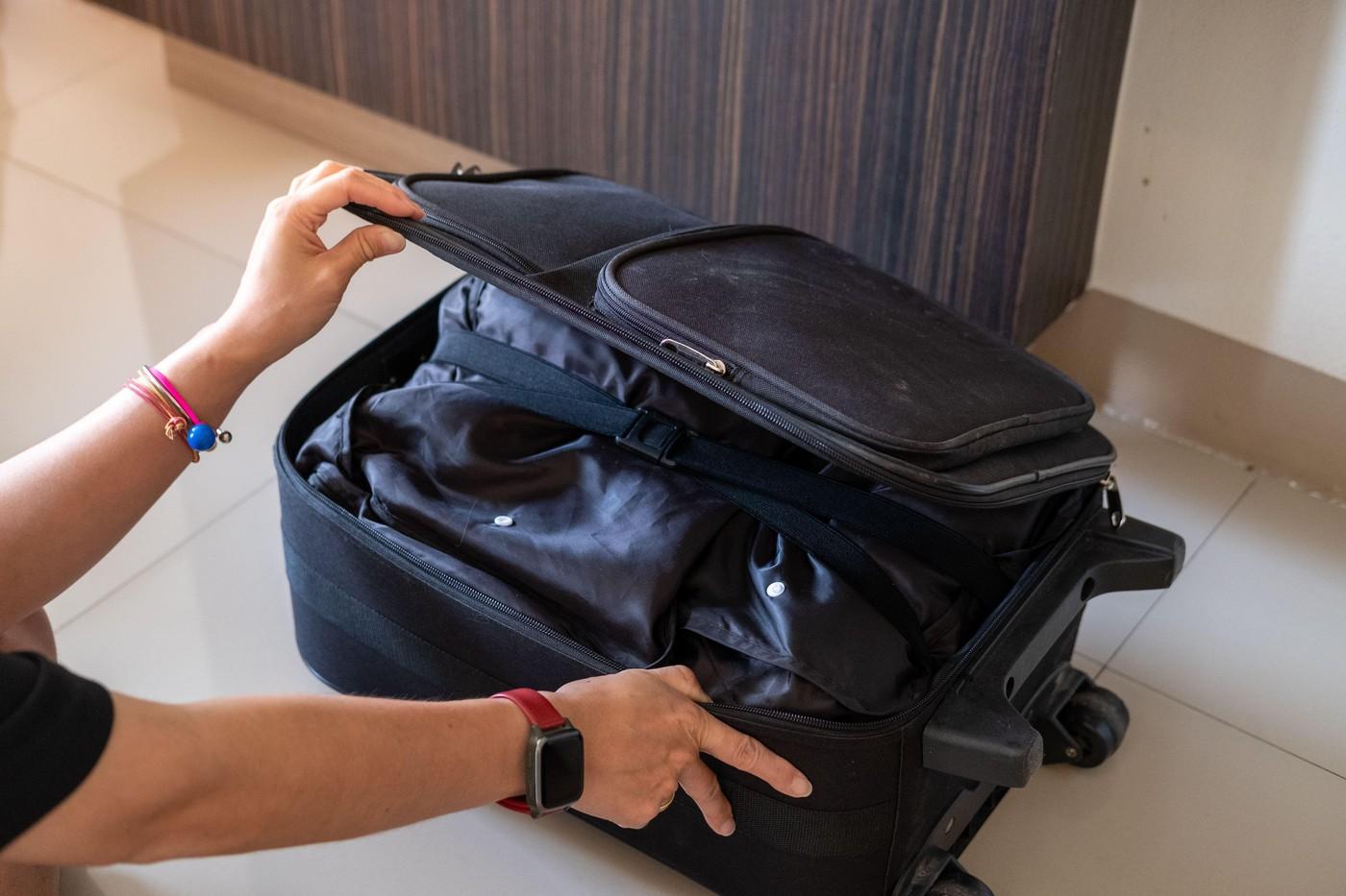 mainile unei femei care fac un bagaj