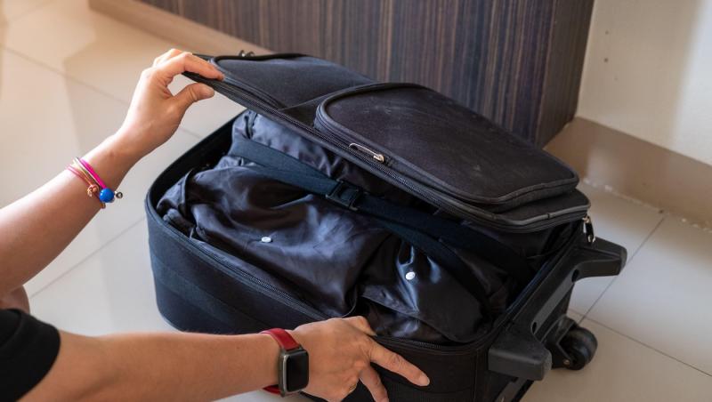 mainile unei femei care fac un bagaj