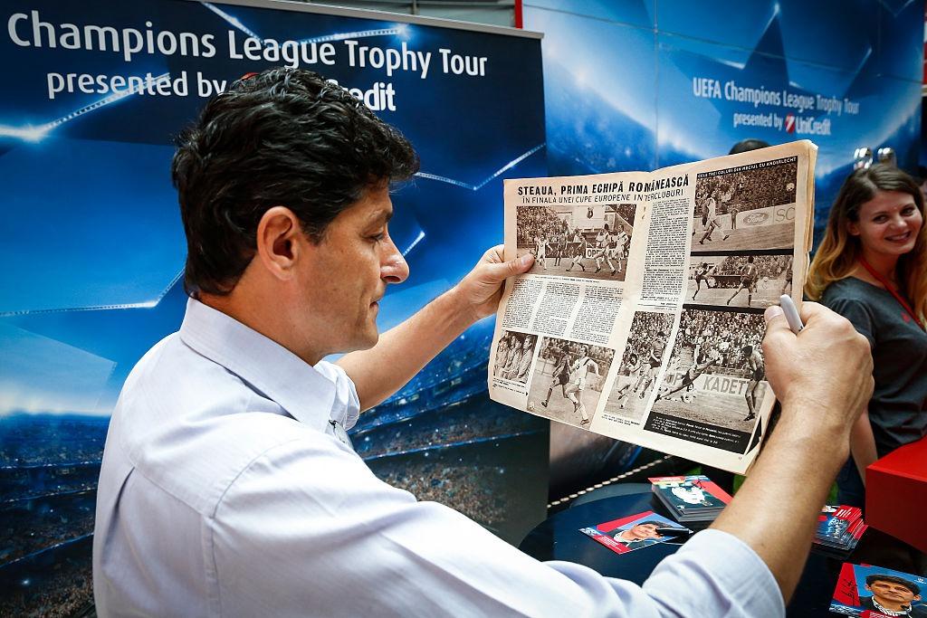 Miodrag Belodedici îmbrăcat cu o cămașă bleumarin, citind un ziar