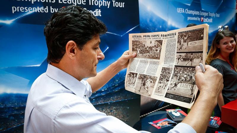 Miodrag Belodedici îmbrăcat cu o cămașă bleumarin, citind un ziar