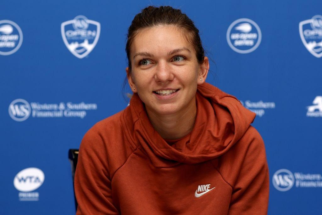 Simona Halep îmbrăcată cu un hanorac cărămiziu, la o conferință de presă