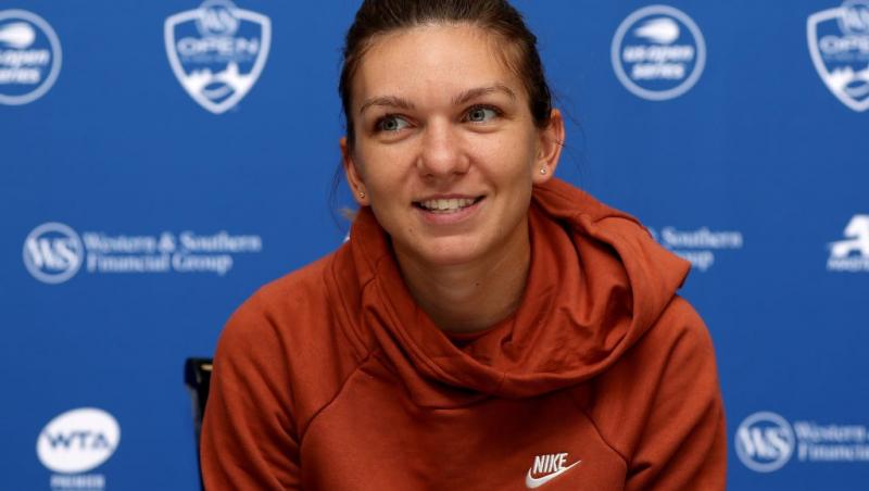 Simona Halep îmbrăcată cu un hanorac cărămiziu, la o conferință de presă