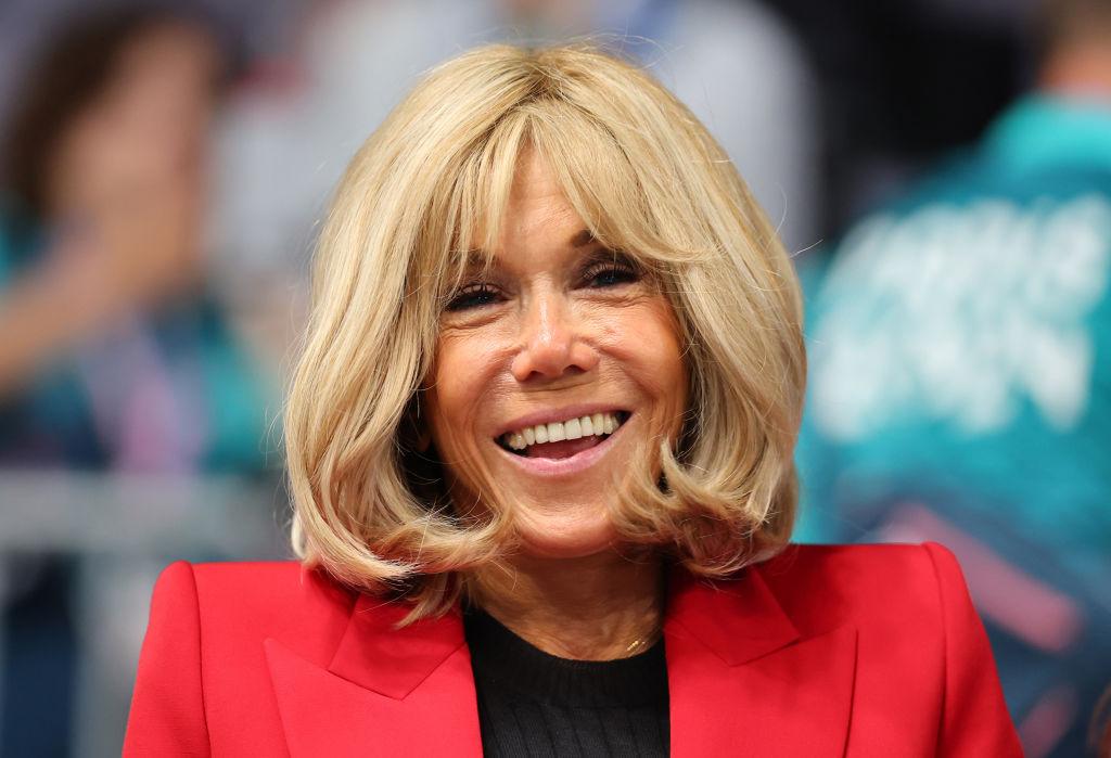 Brigitte Macron îmbrăcată într-un sacou roșu elegant, peste o bluză neagră