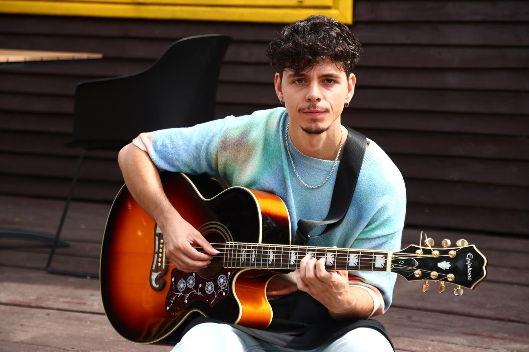 emilian cu o chitară în mână