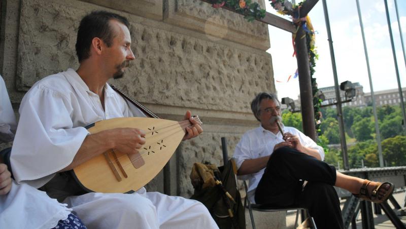 bărbat în costum popular care cântă la cobză și alt bărbat care cântă la fluier