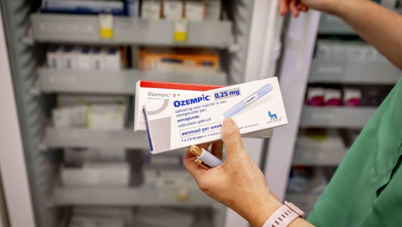 farmacist care ține &icirc;n m&acirc;nă cutii de ozempic