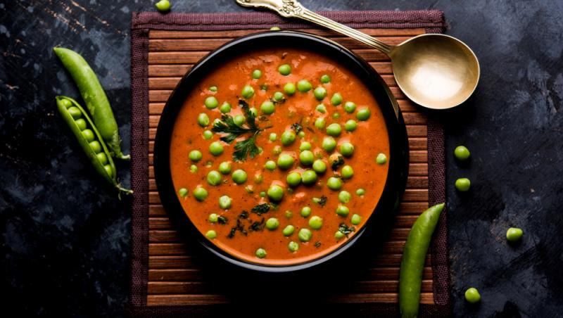 imagine cu o farfurie cu curry de mazare si lingura de decor