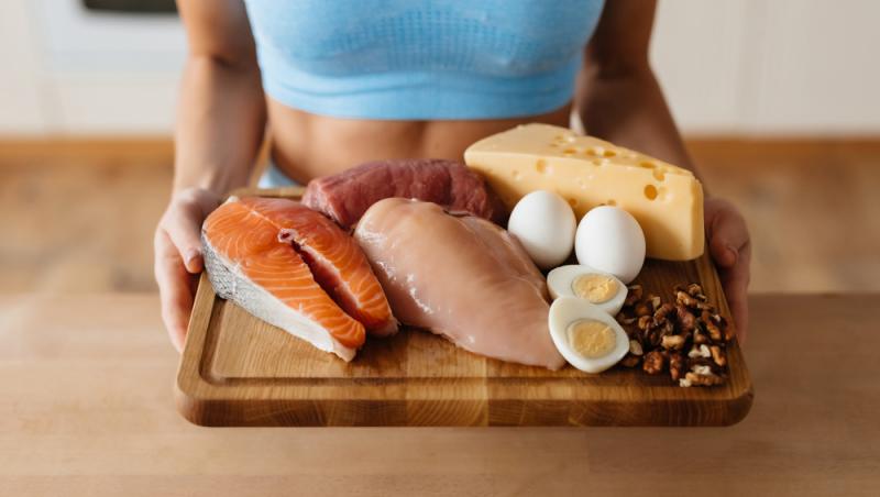 femeie care tine un platou cu alimente bogate in proteina