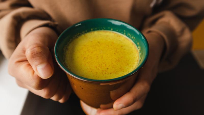 cana cu golden milk tinuta in maini