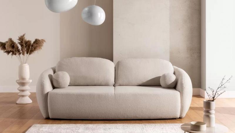 imagine cu un living bej/crem: canapea, covor, lustră, vază, măsuță de cafea