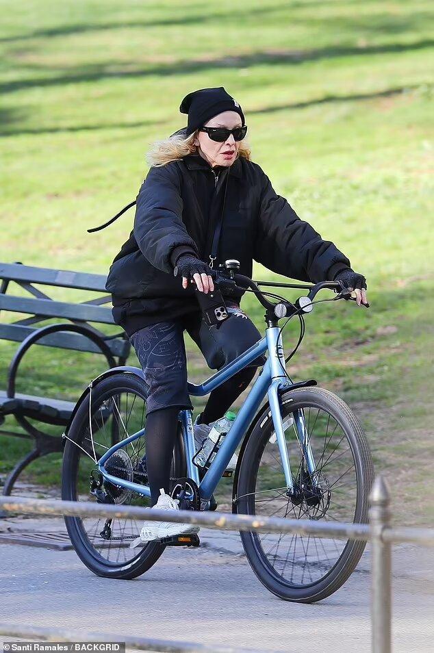 Madonna pe bicicletă, îmbrăcată într-o ținută lejeră de culoare neagră