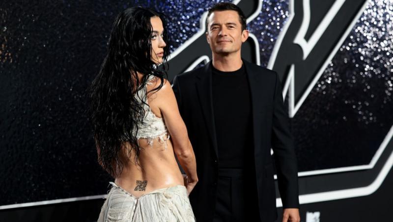 Katy Perry îmbrăcată într-o rochie albă sexy alături de Orlando Bloom îmbrăcat într-o ținută complet neagră