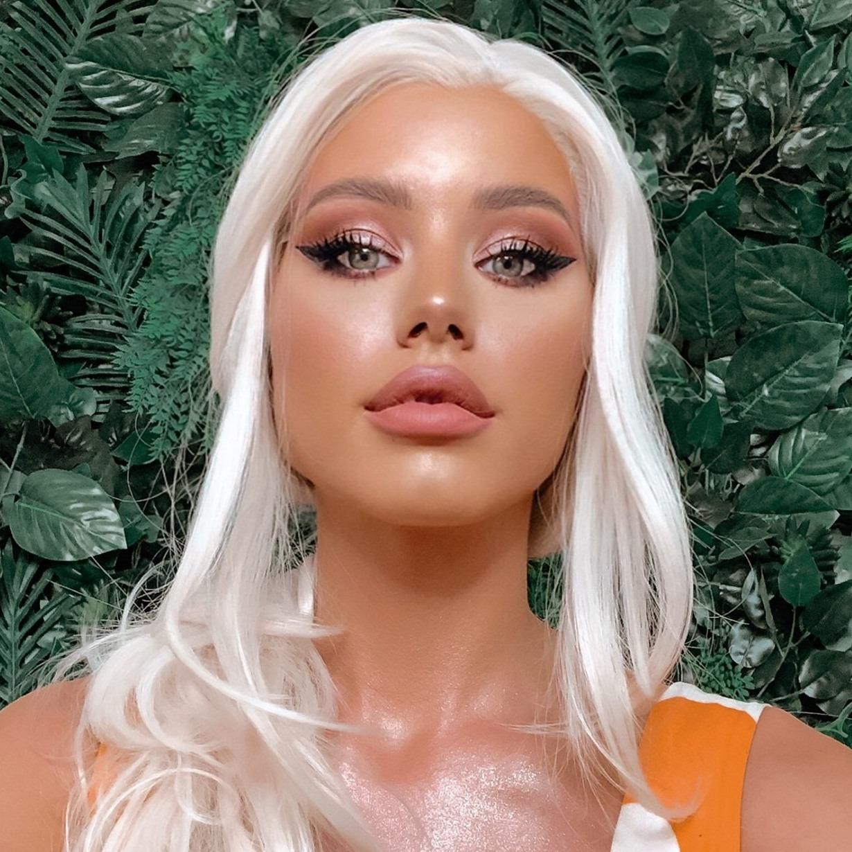 Carmen Grebenișan îmbrăcată cu o rochie portocalie cu detalii albe, fără mâneci