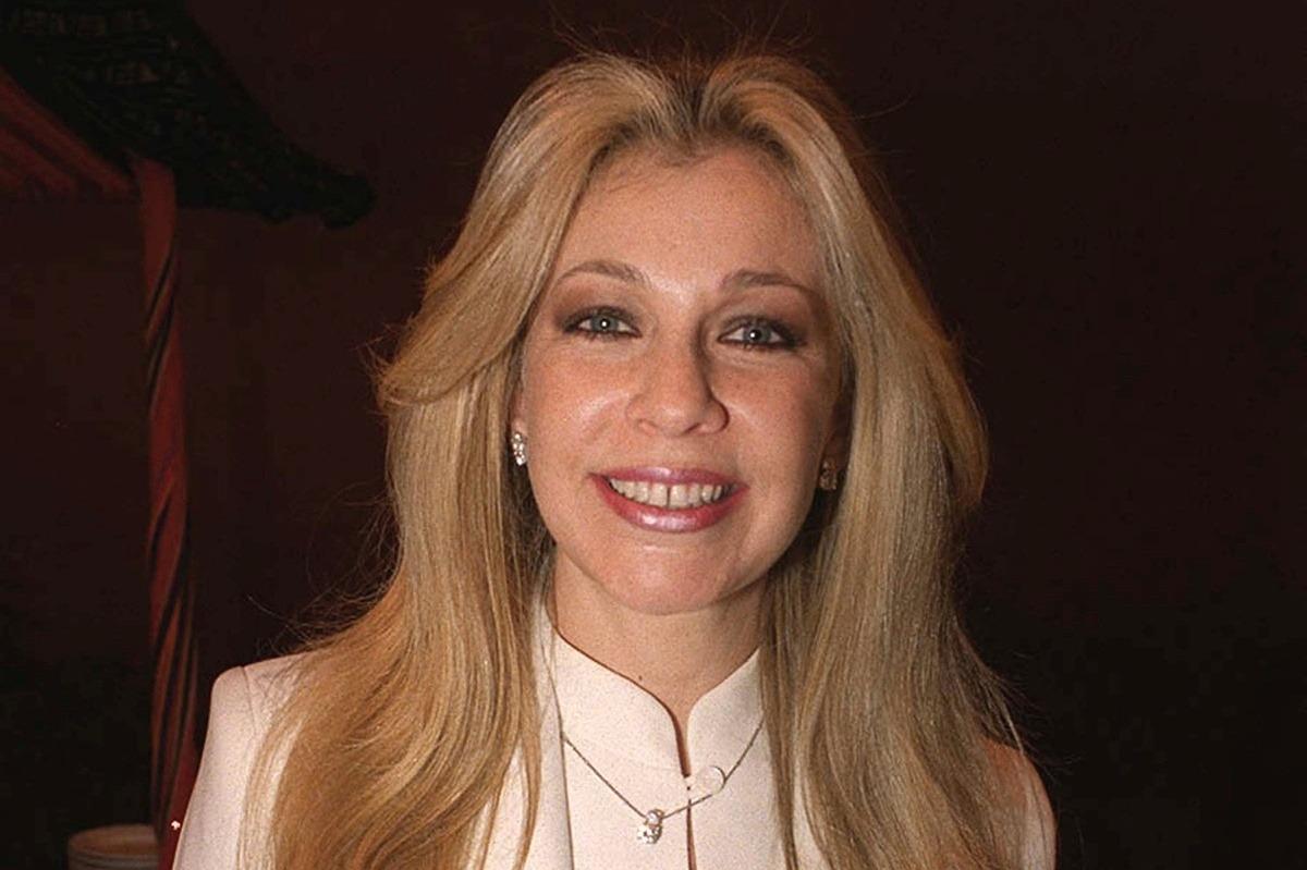 Ernestina Sodi îmbrăcată cu un sacou bej elegant, zâmbind fericită