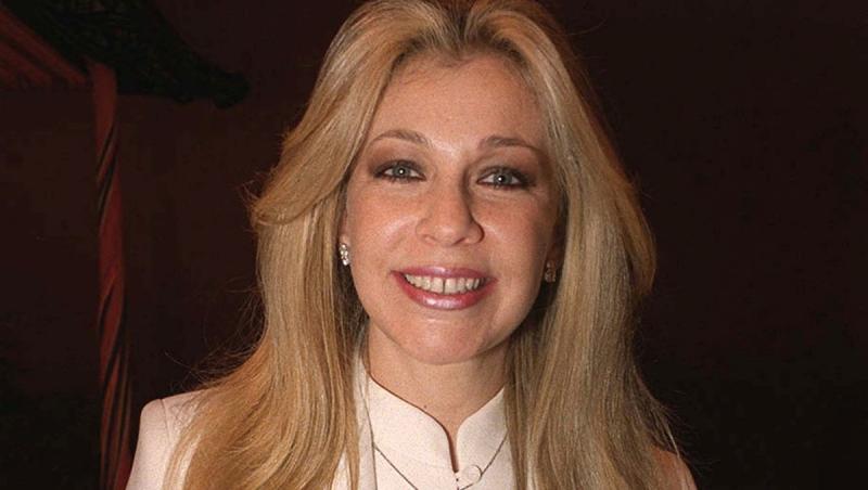 Ernestina Sodi îmbrăcată cu un sacou bej elegant, zâmbind fericită