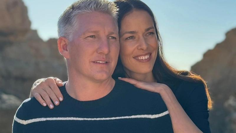 Ana Ivanovic îmbrățișându-l pe Bastian Schweinsteiger de la spate, ambii îmbrăcați casual