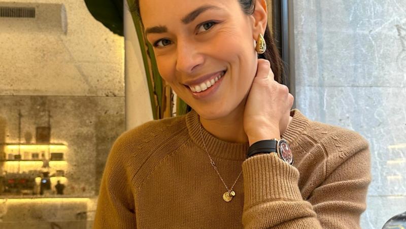 Ana Ivanovic îmbrăcată cu un pulover maro, savurând o cafea
