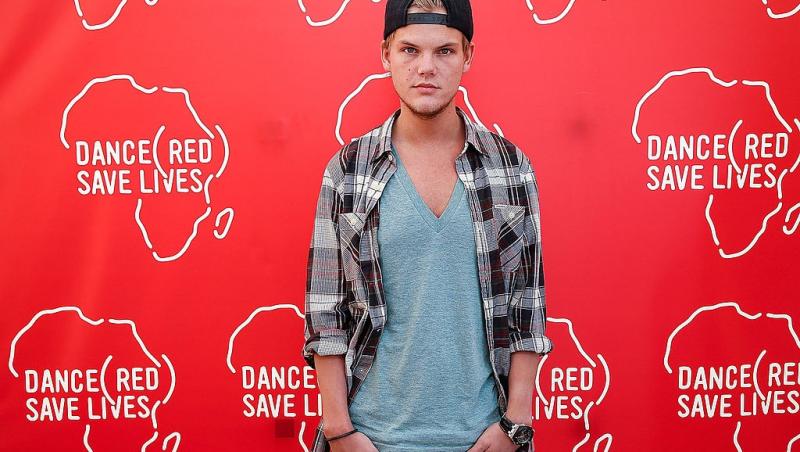 Avicii îmbrăcat casual cu o cămașă în carouri, un tricou și o șapcă, la un eveniment